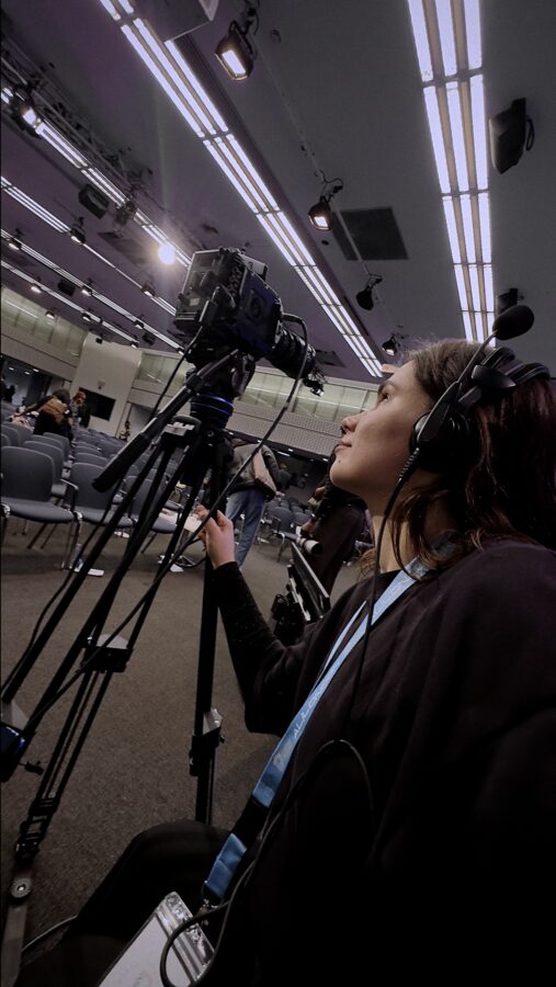 Ana operating a broadcast camera at a conference